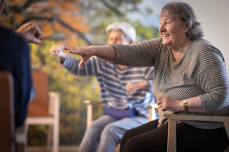 Ihmiset osallistuvat liikuntaharjoitukseen ryhmässä hoivakodissa 