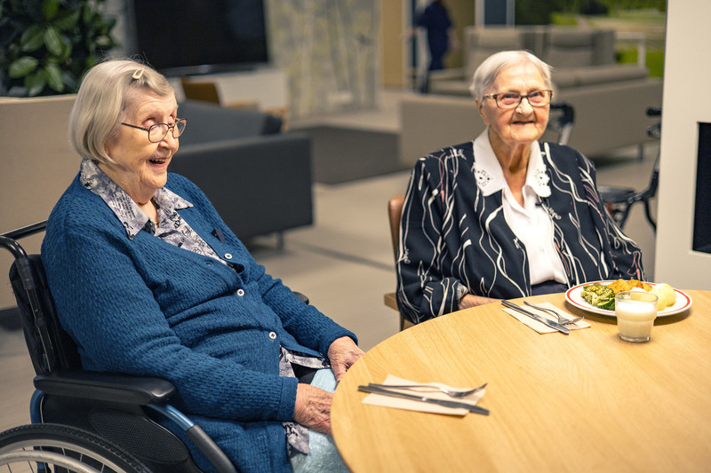 Kaksi vanhempaa naista ruokapöydän ääressä hoivakodissa
