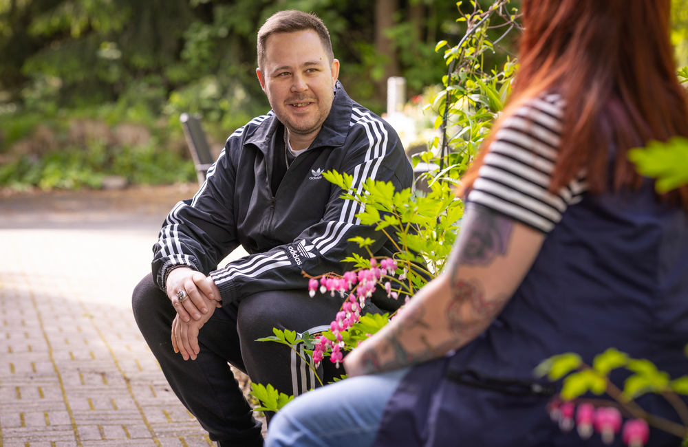 Palvelukodin asukas ulkona ohjaajan kanssa kesäisenä päivänä
