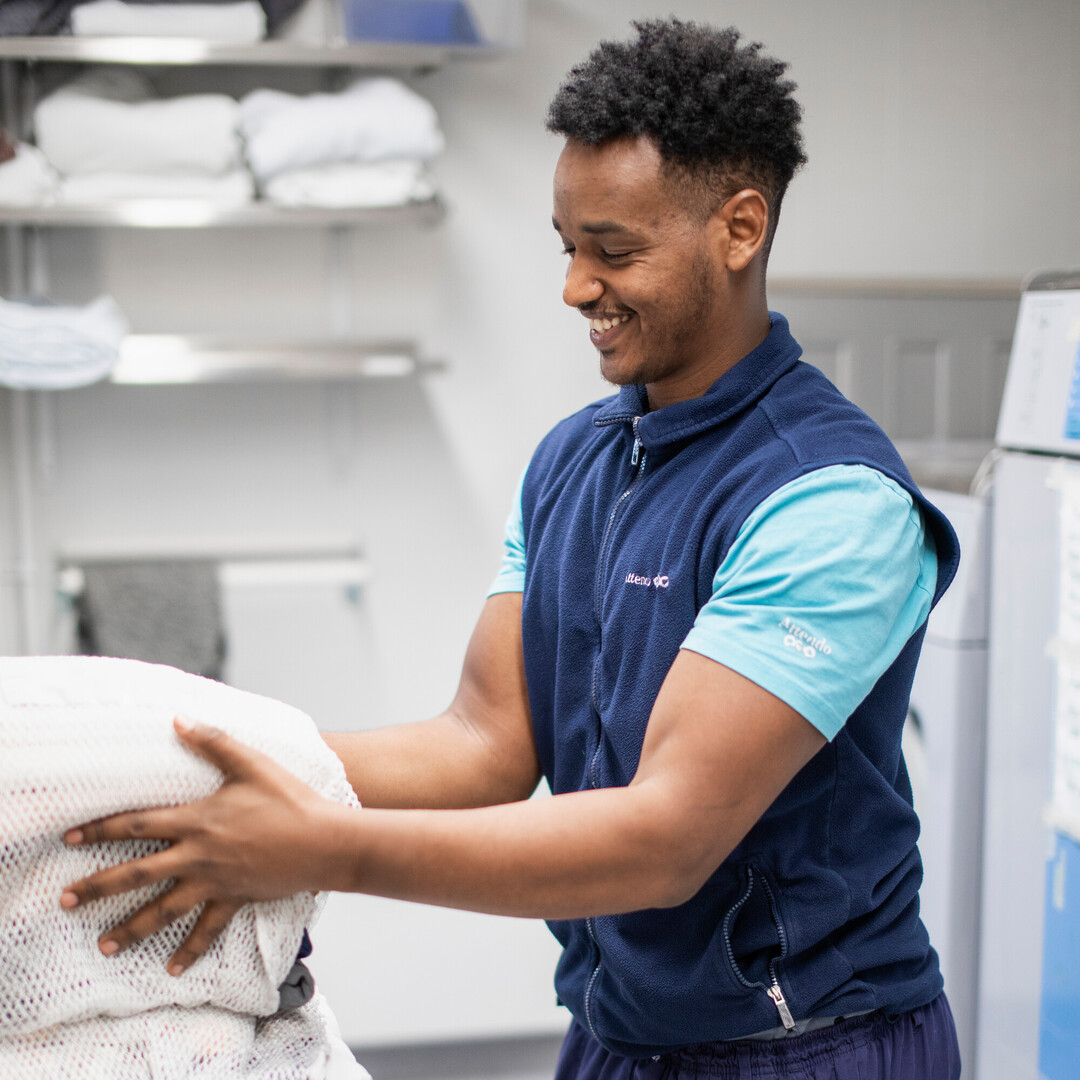 Siistijä ottaa pyykkipussia hoivakodin pesutiloissa