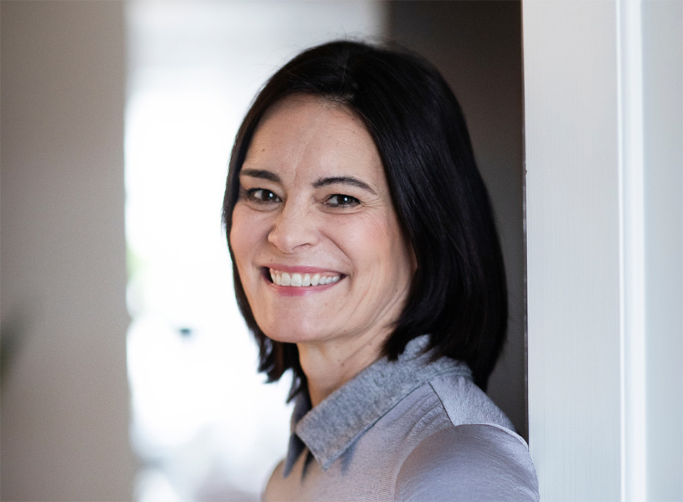 Tummatukkainen Hanna Jensen hymyilee kameralle