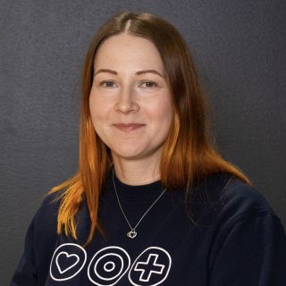 Attendo-kodin johtaja hymyilee sinisessä paidassa