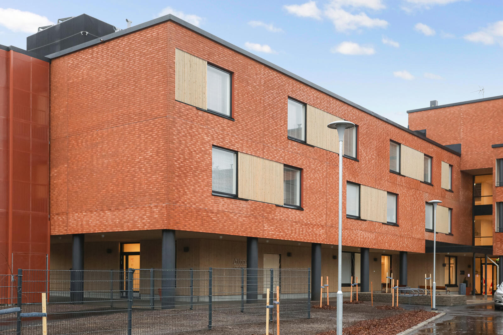 Attendo Salpakankaan talo, jossa punatiilinen julkisivu, suuret ikkunat ja parvekkeet.