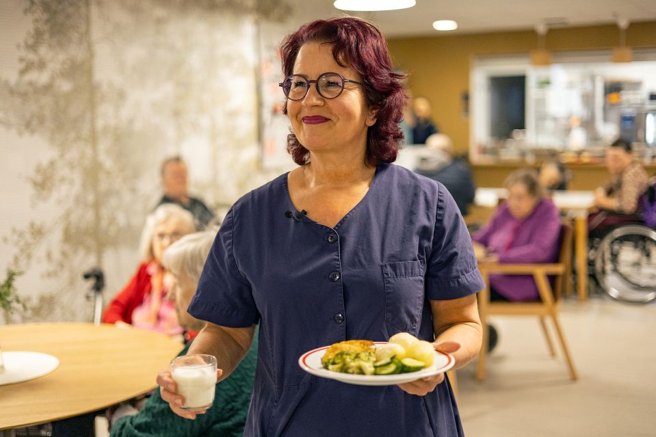 Hoitaja vie lounaan asukkaalle 